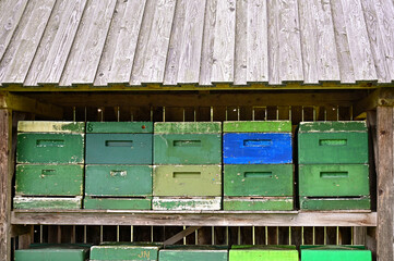 Bienenkästen oder Bienenstockkästen aus Holzkisten stehen in einen Holz-Ständer mit kleinem Dach...