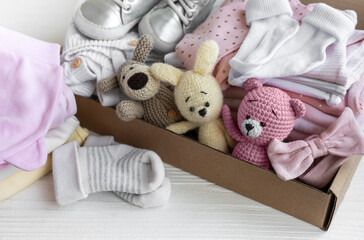 Baby clothes, knitted toys, socks and shoes in box.