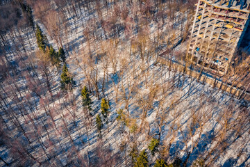 Construction of a high-rise building in early spring. Unfinished construction in the middle of the forest. Aerial morning view of Ternopil cityscape and Zahrebellya city park, Ukraine, Europe. - 787833713