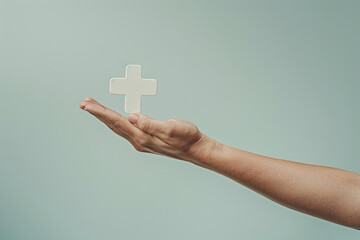 Hand Presenting a White Cross Symbol on Pastel Background