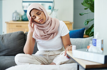 Fototapeta na wymiar Woman, muslim and headache or sick in home, cold and medicine for illness and treatment for health. Female person, hijab and migraine on couch for burnout, pills and stress for crisis or head pain