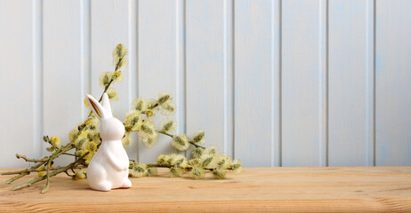 Easter long background with a rabbit figurine and willow branches. Easter background, spring...