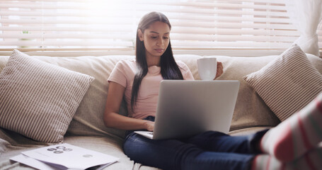 Naklejka premium Sofa, thinking and woman with laptop for remote work, relax and coffee for online paper. Documents, reading and freelancer girl in home with computer for web project, research job and drink on couch.