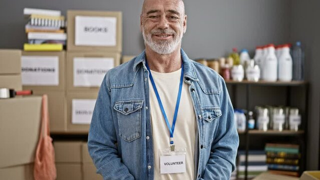 Mature man volunteering at a food bank organizing donations indoors