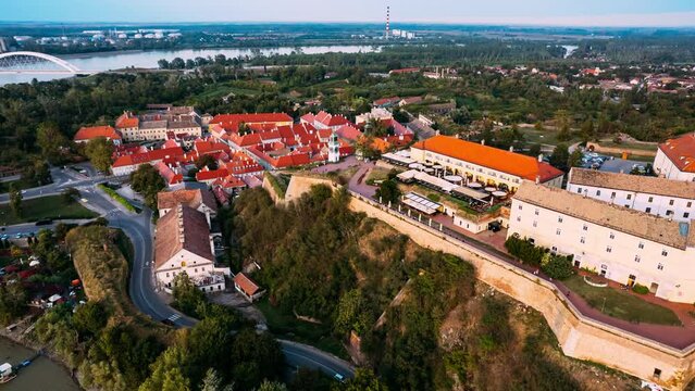 Hyperlapse Timelapse Explore Novi Sad, Serbia from above as a river runs through the city showcasing iconic landmarks like the Petrovaradin Fortress.