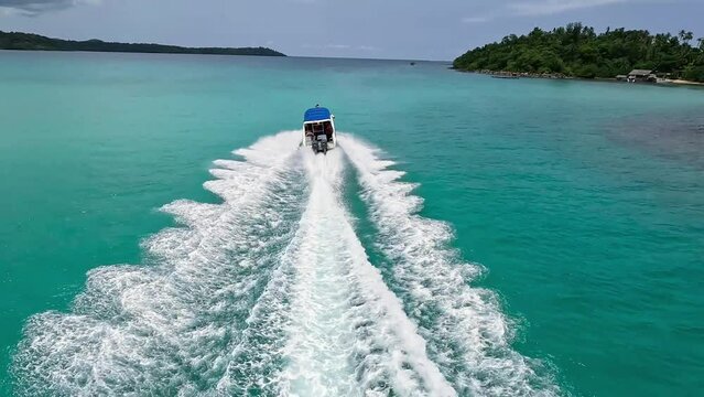 Fpv drone follows a white speedboat in the sea. There are islands and blue waters. Beautiful sea landscape, clear sky. Watch it and feel the excitement. 4K video