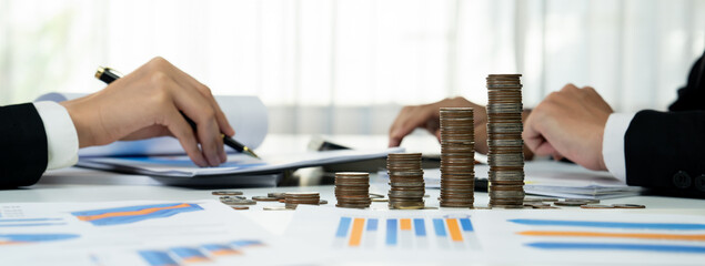 Growth coin stack symbolizing business investment and economic growth. Business people doing...