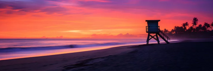 Raamstickers Twilight Tranquility: A Serene Coastal Scene as the Sun Sets over the Palm Trees and Lifeguard Chair © Lelia