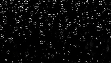 Closeup - rain water drops behind glass look like bubbles in black liquid. Abstract wet background.