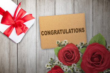 A gift box with a flower bouquet and greeting card with Congratulations text - 787867301