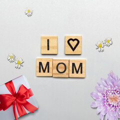 Wooden cubes with I Love Mom text and a gift box - obrazy, fototapety, plakaty