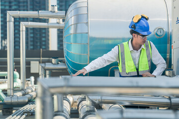 Construction engineer on a rooftop checking HVAC systems, with urban skyline in the distance