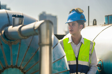 Focused technician conducts maintenance check on rooftop water systems, high-rise buildings in...