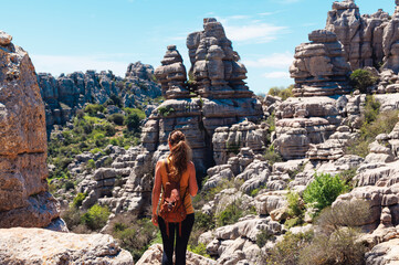 Rear view of tourist woman with bag enjoying landscape natural geologic rock  (torcal)Andalousia in...