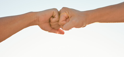 Fist bump, sky and hands of people for support, agreement and collaboration outdoors. Friends, teamwork and closeup of greeting gesture for friendship, community and solidarity on sky background