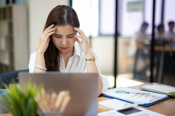 Concerned businesswoman in deep thought, facing work challenges while at her laptop in a busy...