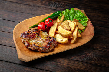 Pork or beef steak with arena potatoes on dark boards background. Menu for a pub