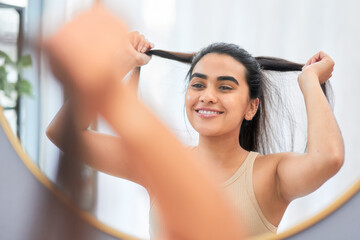 Beauty, mirror and happy woman with hair check. in bathroom with soft, texture or growth...