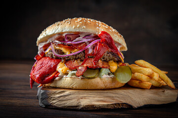 Burger with puffy beef patty, grilled sweet peppers. Juicy delicious hamburger on darkmood picture...