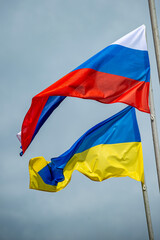 Russian and Ukrainian flags are waving with wind over blue sky. Low angle view. Dispute and conflict concept. Horizontal composition with copy space. - 787925590