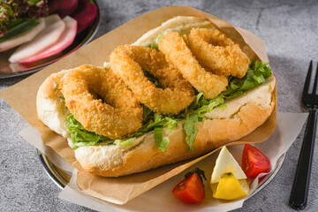 Deep fried squid in bread with greens on the side. Squid sandwich