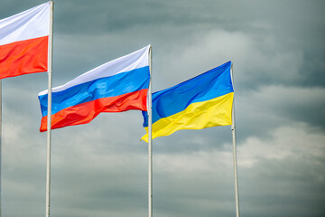 Russian and Ukrainian flags are waving with wind over blue sky. Low angle view. Dispute and conflict concept. Horizontal composition with copy space. - 787927170