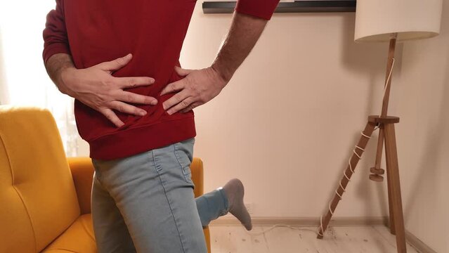 Man with hip, back and sciatica pain at home.