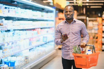 Young african man buying in grocery section at supermarket