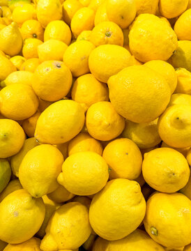 Yellow lemons on a counter in a market as an abstract background. Texture