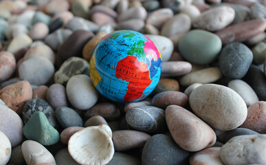African continent on a small globe lying on colored pebbles closeup stock photo
