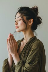 Young Asian woman with namaste hands or prayer hands pose