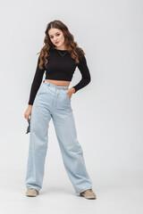 girl model in black shirt and blue trousers jeans posing relaxed in studio - 787956561