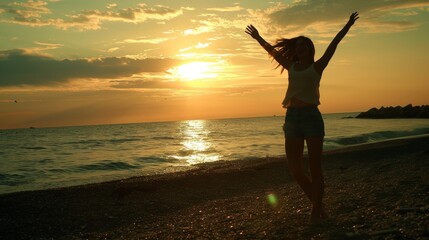 A woman jumps with joy hands raised and embraces freedom on the beach, Sunrise, or sunset on a sandy beach. 