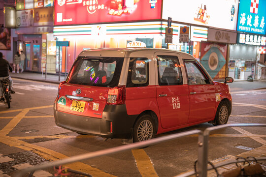Hong Kong - January 20, 2024 :New model red Taxi on the street near Yau ma tei district with passenger in city Hong Kong.