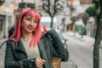 pink haired urban young woman with shopping bags on the street