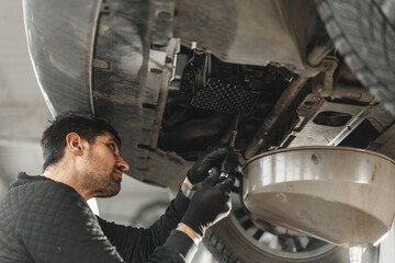 Car mechanic changing oil in a car service - 787966714