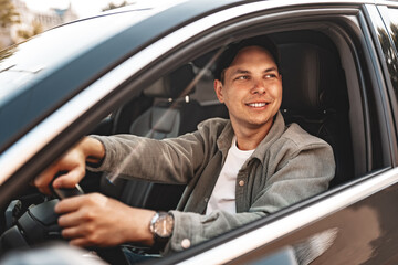 Young smiling man sitting in a car with open window - 787967374