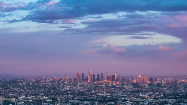 Los Angeles cityscape changing from day to dusk as beautiful sunset clouds pass over DTLA skyline. City timelapse.