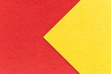 Texture of red paper background, half two colors with yellow arrow, macro. Vintage craft cardboard.