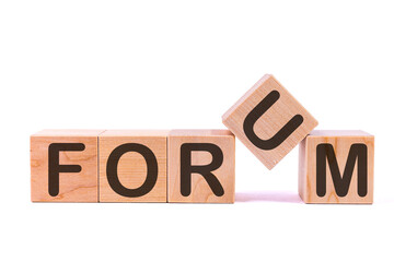 Word FORUM is made of wooden building blocks lying on the table and on a light background. Concept.
