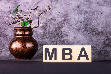 Word MBA made with wood building blocks on a gray background