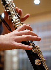 Close up of children's hands playing the clarinet in a music studio
