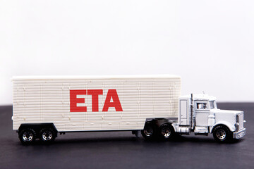 ETA word concept written on board a lorry trailer on a dark table and light background