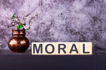 Word MORAL made with wood building blocks on a gray back ground