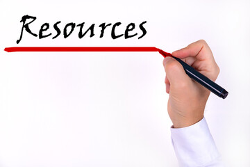 A person writes text, a word, the phrase Resources with marker on a light background. Business...