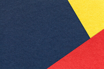 Texture of craft navy blue color paper background with yellow and red border. Vintage abstract denim cardboard.