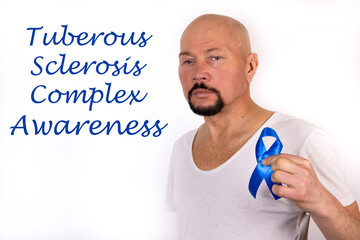 Tuberous sclerosis complex awareness concept. A man in light clothes with a blue ribbon in his...