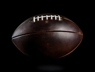 Isolated American football ball on black background with texture, perfect for sports enthusiasts and game-related designs