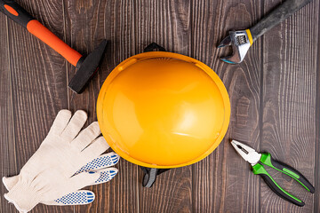 Workers, construction gloves and tool on a wooden background. Clean the house. To make repairs....