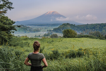 Woman Gazing at a Majestic Mountain Agung Through Lush Greenery in bali